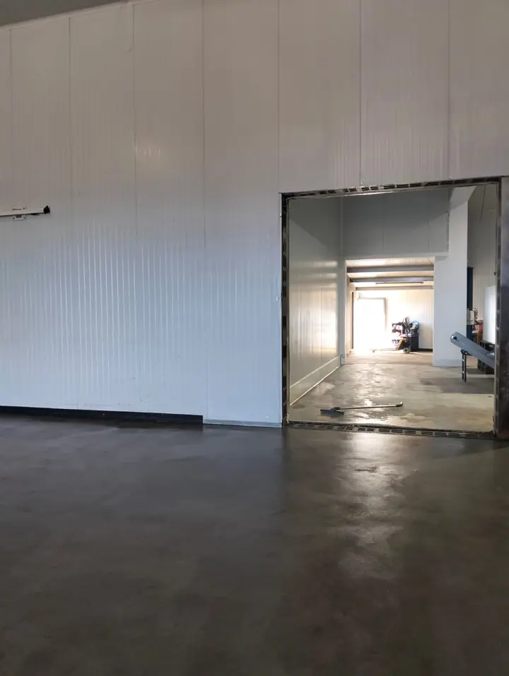 Abertura concluída entre duas câmaras frigoríficas, com o pavimento limpo