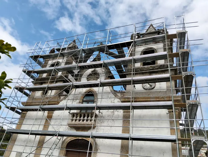 Andaime na fachada de uma igreja em granito