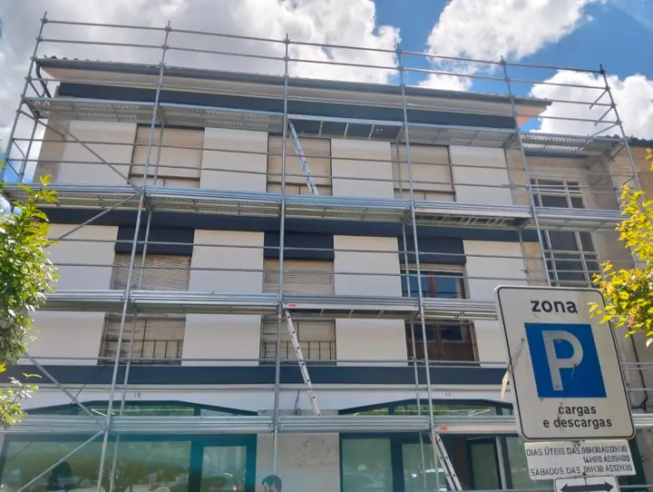 Andaime na fachada de um prédio de rua comercial