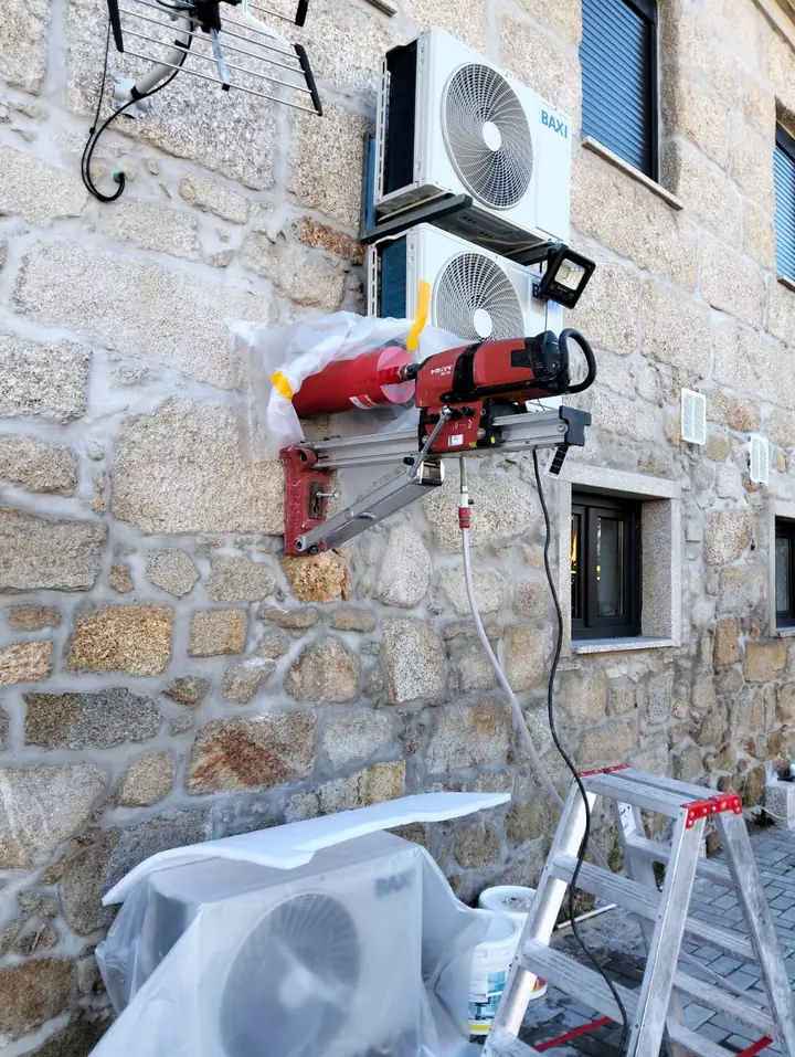 Caroteadora fixa numa parede de granito, com as máquinas de ar condicionado protegidas