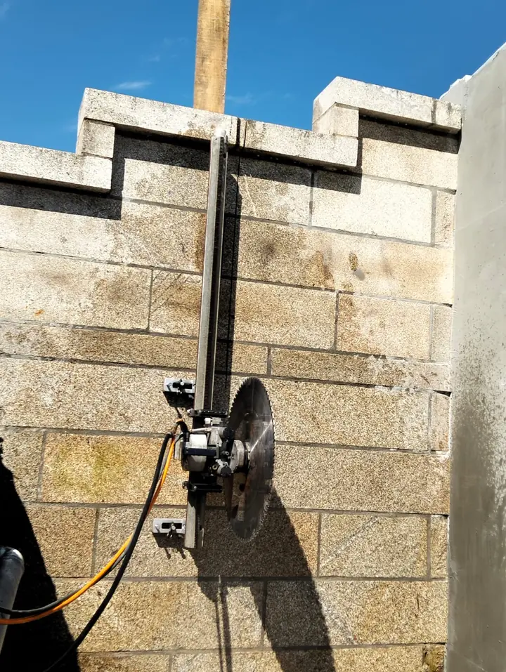 Serra de parede a cortar um muro em blocos de granito