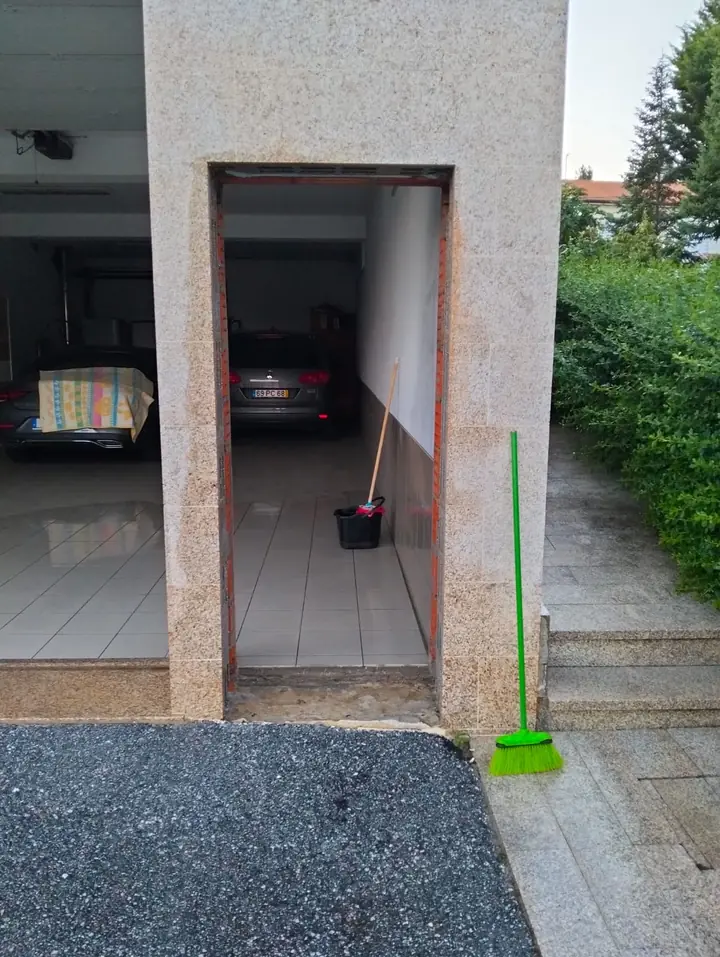Vão de porta aberto numa parede, com passagem para a garagem